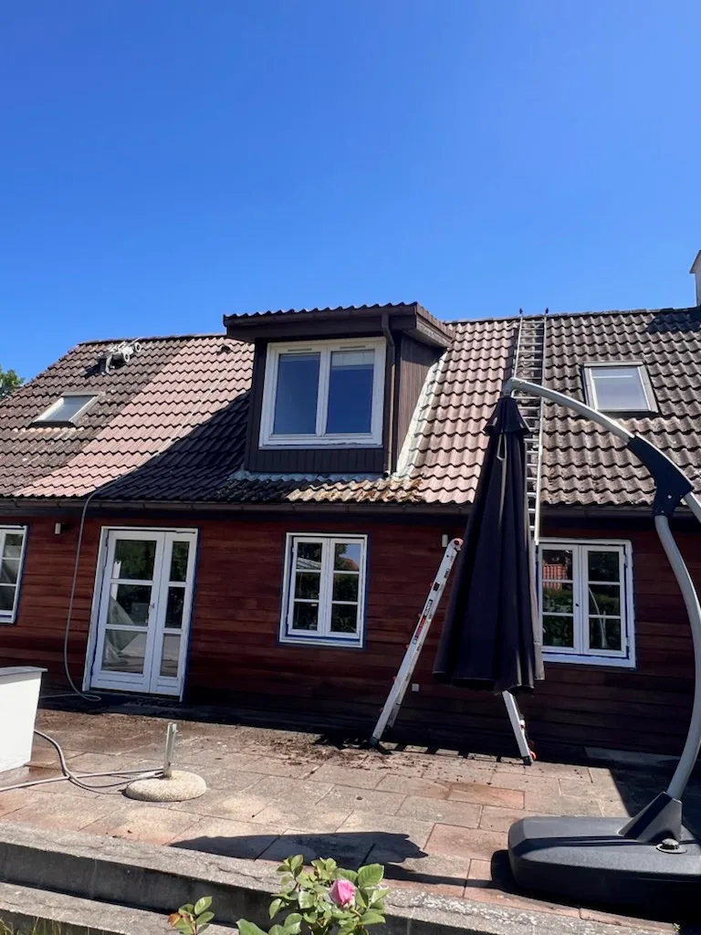 Tagflade midt i en igangværende tagrens, hvor alger og mos er ved at blive fjernet, som ved tagrens i Hellerup